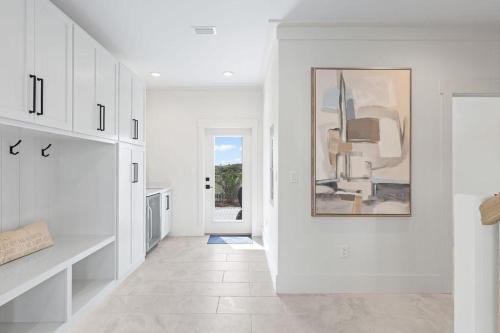 a kitchen with white cabinets and a painting on the wall at 26 Blue Coast Ct in Inlet Beach