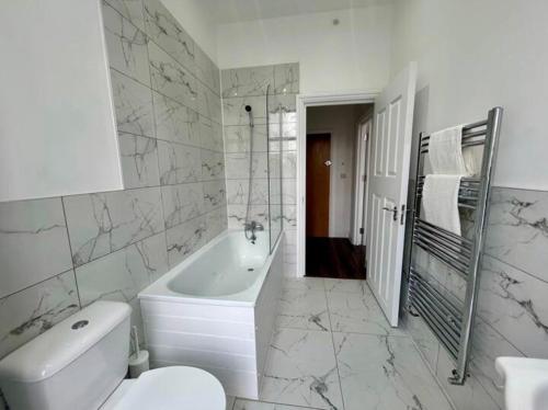 a bathroom with a tub and a toilet and a sink at The 402 Residence in London