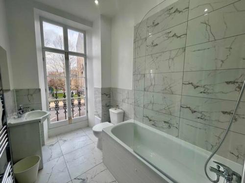 a bathroom with a tub and a toilet and a sink at The 402 Residence in London