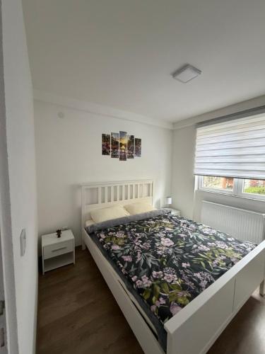 a bedroom with a bed with a floral bedspread at Apartman AURORA Trstenik in Trstenik