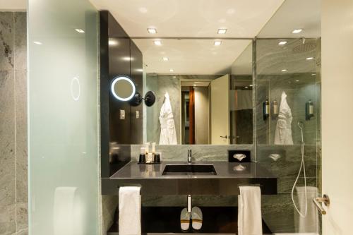 a bathroom with a sink and a large mirror at Altis Grand Hotel in Lisbon