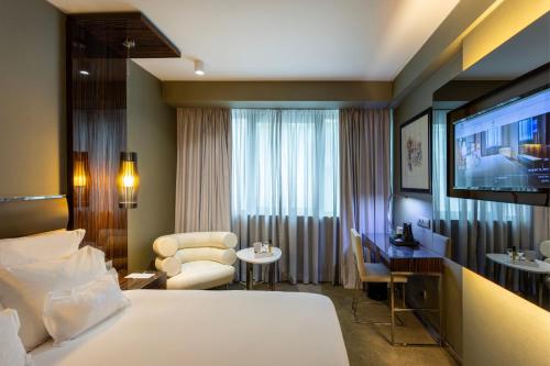 a hotel room with a bed and a television at Altis Grand Hotel in Lisbon