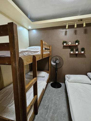 a room with three bunk beds and a fan at Tony nature place in Antipolo