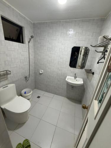 a white bathroom with a toilet and a sink at Tony nature place in Antipolo