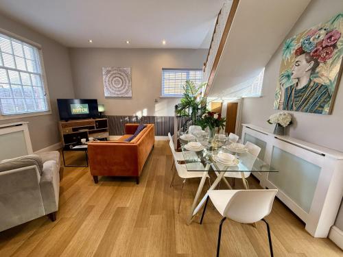 a living room with a table and chairs and a television at Luxury 3-bed Victorian Townhouse Hosted by Hutch Lifestyle in Leamington Spa