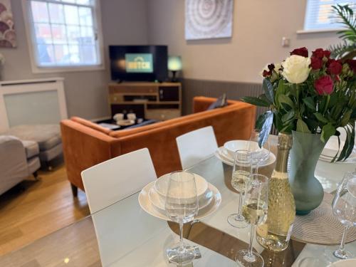 a living room with a glass table with wine glasses at Luxury 3-bed Victorian Townhouse Hosted by Hutch Lifestyle in Leamington Spa