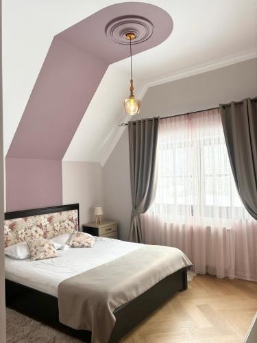 a bedroom with a large bed and a window at Pensiunea agroturistica Elena in Drăgoiasa