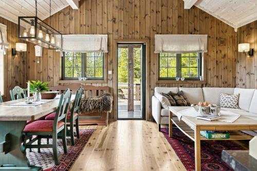 a living room with a couch and a table at Mountain Cabin With Great Views in Austbygdi