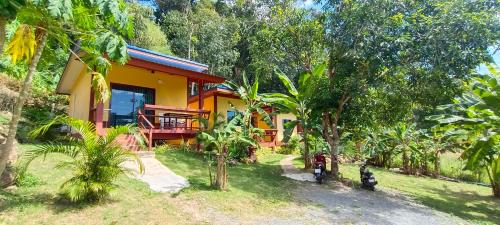 a yellow house in the middle of a forest at Alisa Bungalows in Ko Chang