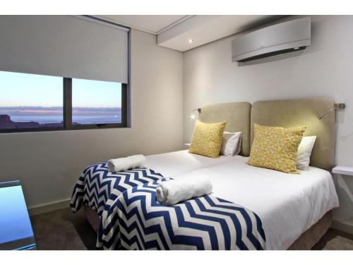 1 dormitorio con 1 cama grande con almohadas amarillas y negras en Fairmont 1001, en Ciudad del Cabo