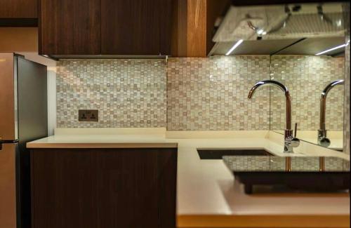 a kitchen with a sink and two faucets at Aeon Towers Davao Condotel near Abreeza Ayala Mall in Davao City