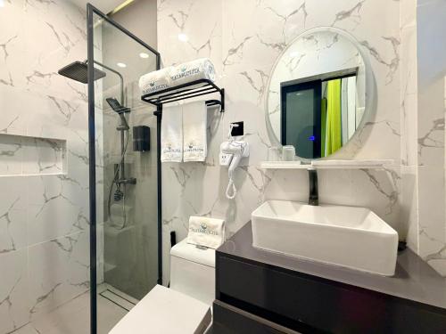 a white bathroom with a sink and a mirror at PlayaLolita Beach Resort in Calatagan