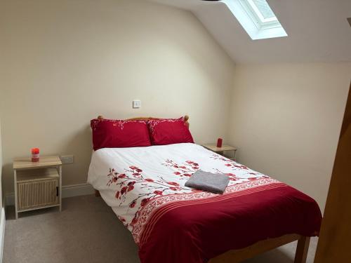a bedroom with a bed with a red and white comforter at Riverchapel Guesthouse in Courtown