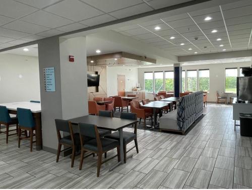 a dining room with tables and chairs in a cafeteria at Holiday Inn Express Hotel & Suites Tipp City by IHG in Tipp City