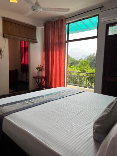 a bedroom with a bed and a large window at Rock House Villa in Kandy
