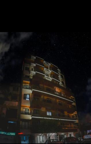 a tall apartment building at night with stars at Alcazar Suites Premium in Salta