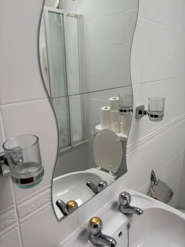 a bathroom with a sink with a mirror and a sink at Riverchapel Guesthouse in Courtown