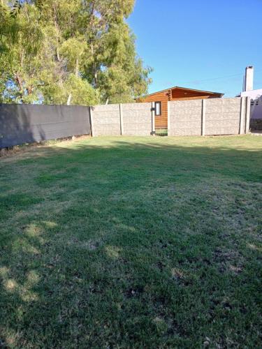a large yard with a fence and a building at Cabaña Doña Loly in Olavarría