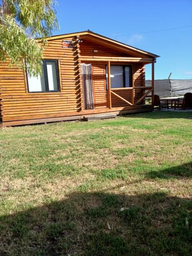 a log cabin with a bench in a yard at Cabaña Doña Loly in Olavarría