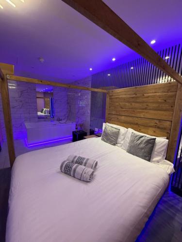 a large white bed in a room with a tub at Luxury Jacuzzi Suites Halifax in Halifax