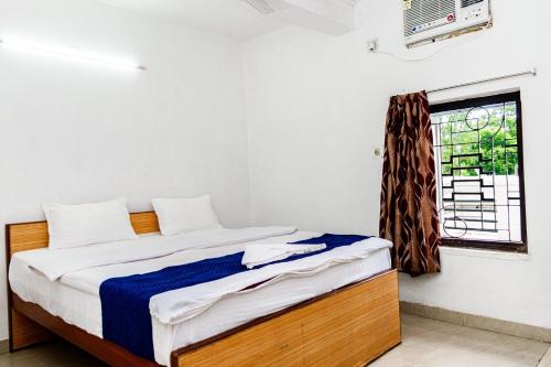 a bedroom with a bed and a window at Hotel Soft Petal BB Block in Kolkata