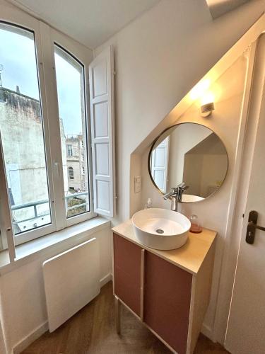 a bathroom with a sink and a mirror at Canopée - Appartement - Hyper centre ville in Quimper