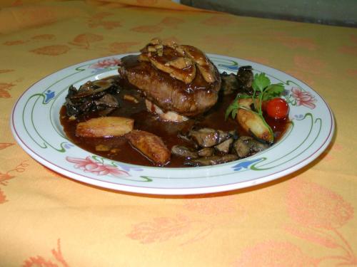 a plate of food with meat and vegetables on a table at Hostellerie de la Bouriane in Gourdon-en-quercy