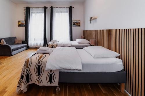 a bedroom with three beds and a couch at Jasminn Apartments in Prague