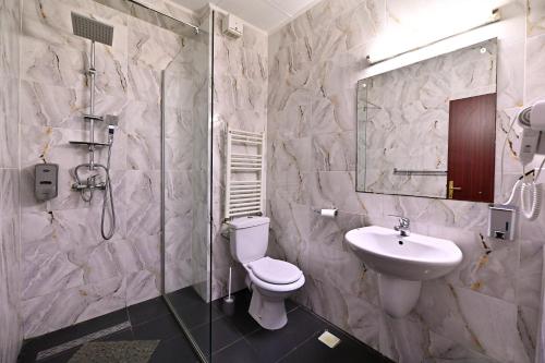 a bathroom with a toilet and a sink and a shower at Hotel Magic GT Trivale in Piteşti