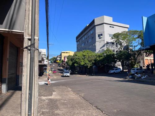 a girl is standing on the side of a city street at Pousada Fronteira City in Foz do Iguaçu