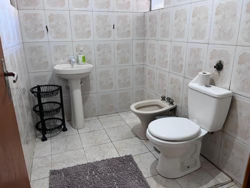 a bathroom with a toilet and a sink at Pousada Fronteira City in Foz do Iguaçu
