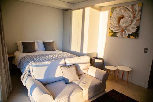 a bedroom with a bed and a couch in it at Ad Astra Studio Apartment - Waterfall in Midrand
