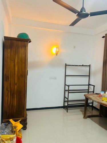 a living room with a ceiling fan and a table at Senuka Villa in Mirissa