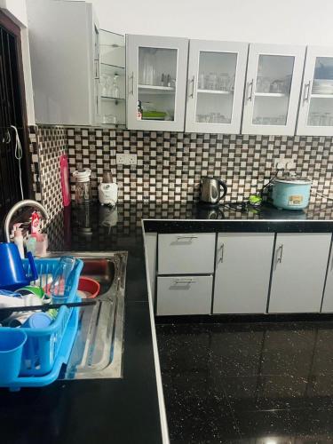 a kitchen with white cabinets and a sink at Senuka Villa in Mirissa