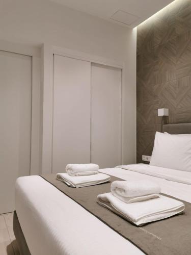 a bedroom with two beds with towels on them at O!live Fully Equipped Apartments with Unique Design in Athens