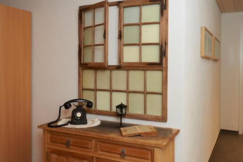 a telephone on a wooden dresser with a mirror at Gasthof Bären in Ranflüh
