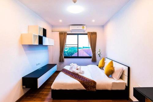 a bedroom with a bed and a window in a room at V-twin Condo Donjan in Chiang Mai
