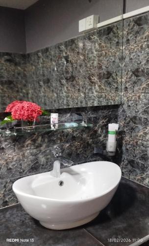 a white sink in a bathroom with marble walls at Voyager's Villa in Habarana