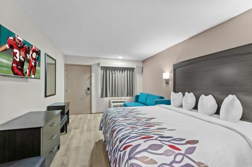 a hotel room with a large bed and a desk at Red Roof Inn Panama City Beach in Panama City Beach