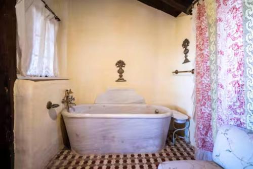 an old tub in a bathroom with a window at Casa Museo RAKKANA - En el Centro de Requena in Requena