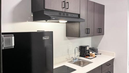 a kitchen with a black refrigerator and a sink at Studio 6 Houston TX Pearland Medical Center in Houston