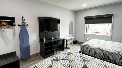a bedroom with a bed and a desk and a television at Studio 6 Houston TX Pearland Medical Center in Houston