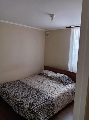 a small bedroom with a bed in a room at departamento Eli in Valdivia