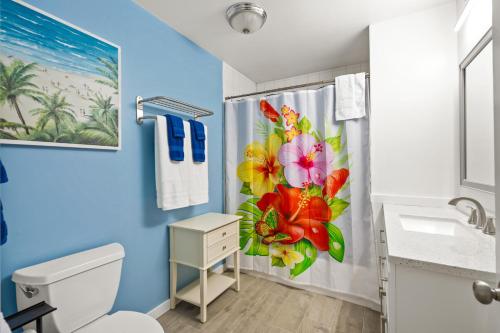 a bathroom with a shower curtain with flowers on it at Walk to the Beach and Village - Hibiscus Villa in Siesta Key