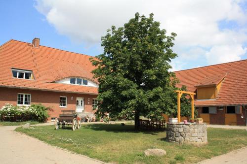 a building with a tree in front of a building at Pferdehof Ruhnau in Potzlow
