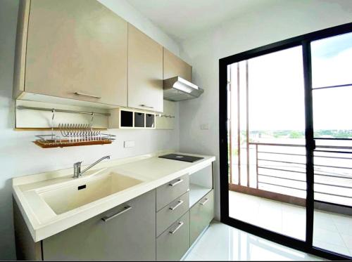 a kitchen with a sink and a large window at V-twin Condo Donjan in Chiang Mai