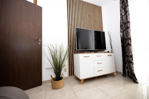 a living room with a tv on a white dresser at Apartament IKAR blisko morza in Rewal