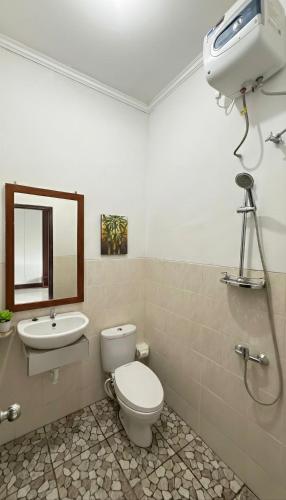 a bathroom with a toilet and a sink at Amerthya Villa in Banjar