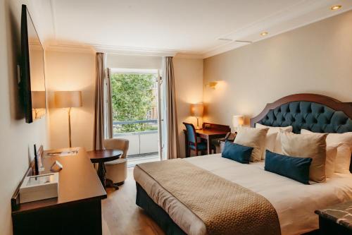 a hotel room with a large bed and a window at Grand Hotel Karel V, WorldHotels Luxury in Utrecht
