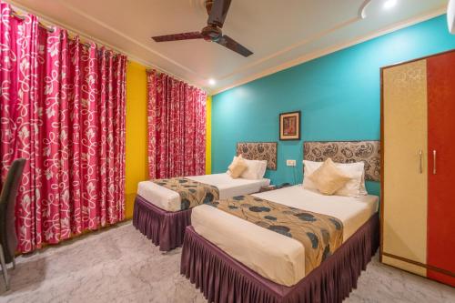 two beds in a room with colorful walls and curtains at Tara Inn in Varanasi